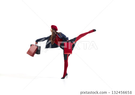Fashion woman in red beret holding shopping bags with raised leg in dynamic balance 132456658