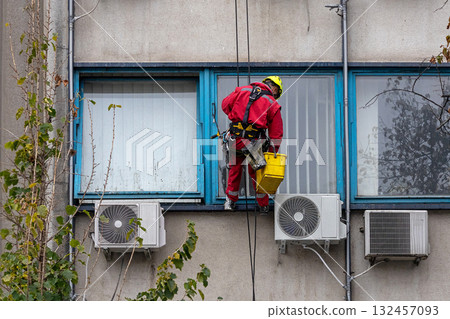 Man washing windows on building facade 132457093