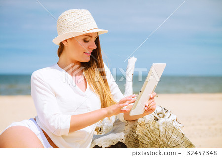 Girl with tablet on seaside. 132457348