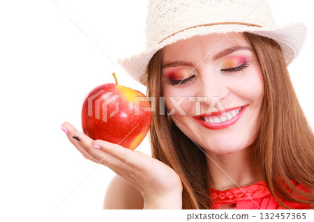 Woman summer hat colorful makeup holds apple fruit Woman summer hat colorful makeup holds apple fruit 132457365