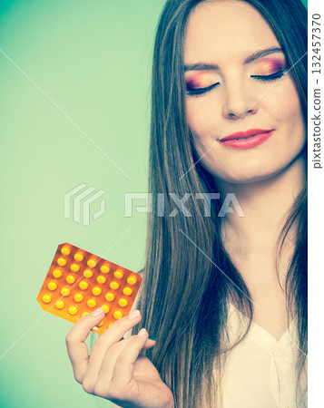 Woman holding pills blister pack vitamin c Woman holding pills blister pack vitamin c 132457370