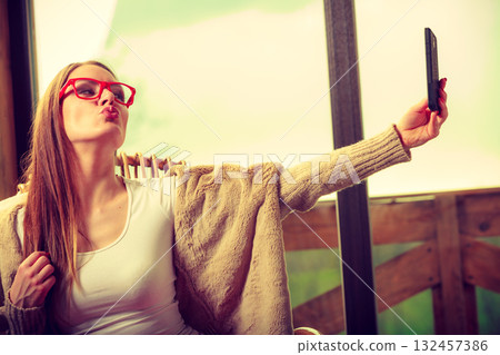 Woman sitting on chair making selfie at home Woman sitting on chair making selfie at home 132457386