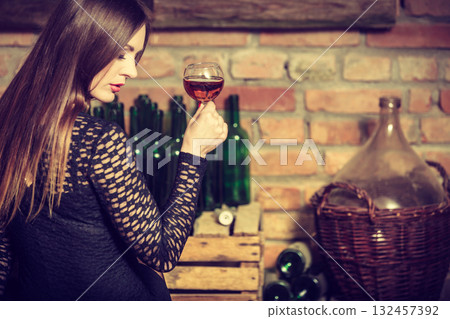 Woman tasting wine in rural cottage interior 132457392
