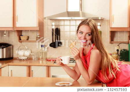 Woman with tea coffee eating gingerbread cookie. 132457593