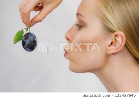 Girl holds plum fruit 132457640