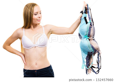 Woman holds bras, choosing Woman holds bras, choosing 132457660