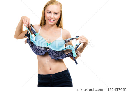 Female holds bras. Bra fitting 132457661