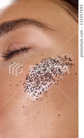 Macro view of female face with exfoliating cream and scrub particles on cheek. Macro view of female face with exfoliating cream and scrub particles on cheek. 132457693