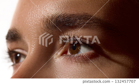 Eyes and brows close-up with glowing natural skin under soft light 132457707