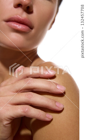 Woman touching bare shoulder showing soft hydrated skin and calm mood Woman touching bare shoulder showing soft hydrated skin and calm mood 132457708
