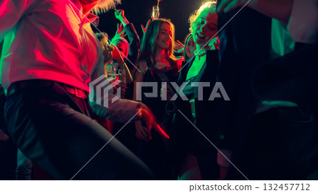 Dancing crowd in Christmas party with champagne and bright red-green lights Dancing crowd in Christmas party with champagne and bright red-green lights 132457712