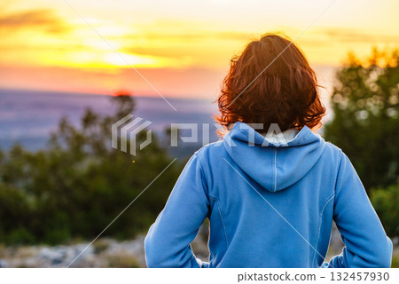 Woman enjoying sunset view. 132457930