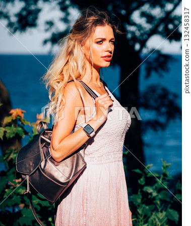 Casual girl with backpack on sea coast Casual girl with backpack on sea coast 132458317