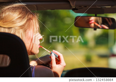 Girl apply make up while driving car. 132458664