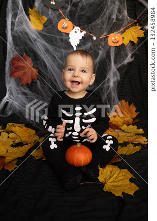 Baby in Skeleton Costume with Pumpkin and Leaves 132458984