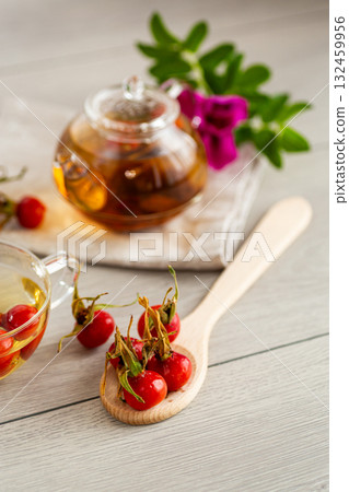 Medicinal rosehip tea in a cup on a wooden table Medicinal rosehip tea in a cup on a wooden table 132459956