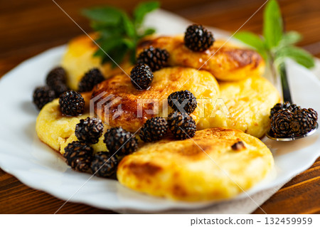 Golden cottage cheese fritters with sweet pine cone jam 132459959