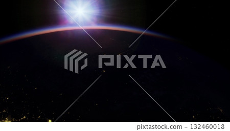 A breathtaking view shows Earths curvature from space with a glowing sun rising at the horizon. Distant city lights sparkle below, highlighting the beauty of our planet. 132460018