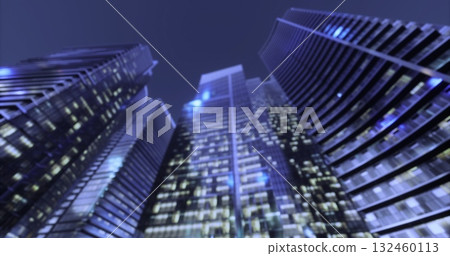 Tall skyscrapers tower over the city, their windows glowing with bright lights against a deep blue dusk. The urban landscape highlights modern architecture and vibrant nightlife. 132460113