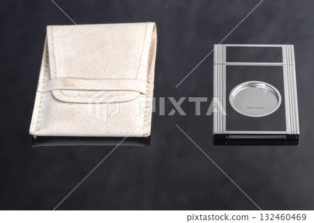 A gray metal guillotine with a sharp cigar cutter on a dark background. 132460469