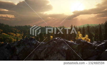 Morning light breaks through the clouds, illuminating the lush forest and rocky landscape. Trees stand tall, while golden leaves shimmer in the soft glow, creating a serene atmosphere. 132460594