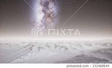 A breathtaking view of snow covered peaks extending under a vibrant Milky Way at night. The clear sky sparkles with countless stars, creating a magical winter landscape. 132460644