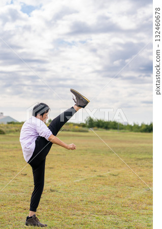 Man stretching with leg raised | Dynamic warm-up Man stretching with leg raised | Dynamic warm-up 132460678