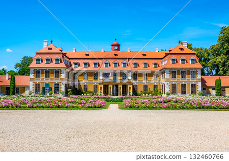 Panoramic view of Rajec Jestrebi Chateau on a sunny summer day with blue sky, blooming pink roses, and a fountain in front of the historical building. 132460766