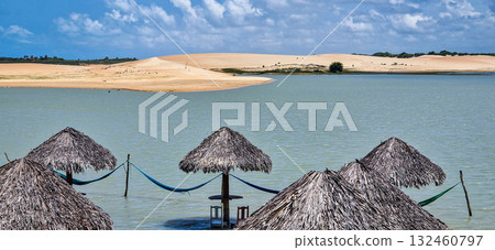 Straw huts on the banks of the Torta Lagoon, Tatajuba Beach at Jijoca de Jericoacoara, Ceara in Brazil 132460797