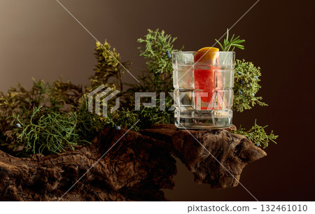 Refreshing hard seltzer with ice, grapefruit, and rosemary on an old snag. 132461010