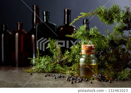 Juniper berry essential oil and branches with fresh berries. Juniper berry essential oil and branches with fresh berries. 132461023
