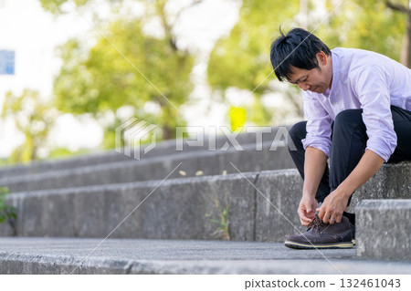 男人在樓梯上繫鞋帶 132461043