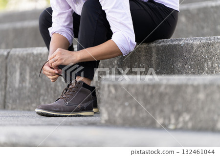 男人在樓梯上繫鞋帶 132461044