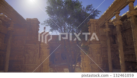A warm sun illuminates a courtyard featuring intricately carved pillars and a solitary tree. The ancient architecture reflects rich cultural heritage in this serene historical site. 132461059