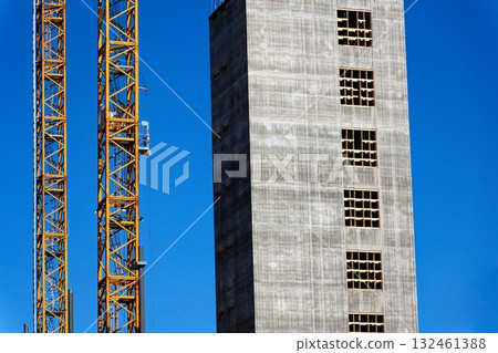 Two yellow cranes on skyscraper construction site of timber building Kaj 16 with hybrid concrete frames, sunny day, Lilla Bommen area, Gothenburg, Sweden 132461388