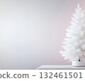 Minimalist white tree against pastel wall. Soft light enhances cozy, contemporary festive mood. 132461501