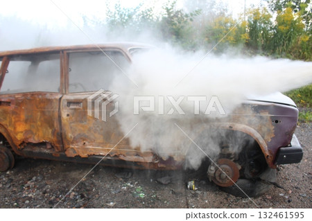extinguishing a burnt car at the workshop. Using a fire extinguisher 132461595