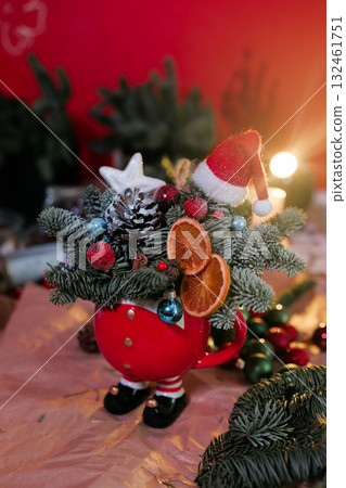 Winter Christmas bouquet in funny bowl on the table by the window.  132461751