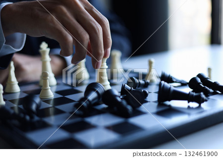 Businessman wearing suit, playing chess, game, Business strategy, leadership and management concept. 132461900