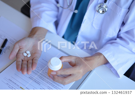 Doctor or General practitioner explain to patient how to use prescribed medicine correctly by explain dosage, frequency, and timing. Doctor or General practitioner explain to patient how to use prescribed medicine correctly by explain dosage, frequency, and timing. 132461937