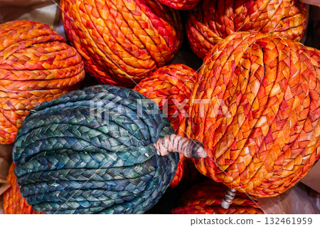 Colorful woven pumpkins made from braided natural fibers in shades of orange and teal. Eco-friendly seasonal decor, sustainable craftsmanship, autumn home styling, plastic-free holidays Colorful woven pumpkins made from braided natural fibers in shades of orange and teal. Eco-friendly seasonal decor, sustainable craftsmanship, autumn home styling, plastic-free holidays 132461959