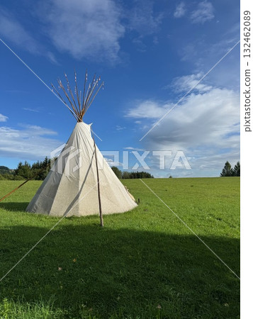 Teepee is standing in a grassy field 132462089