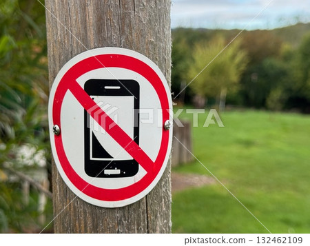 No cell phone sign is on a wooden pole No cell phone sign is on a wooden pole 132462109