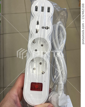 White power strip with multiple outlets and USB ports, featuring a red power indicator, designed for home and office use, showcasing modern electrical convenience White power strip with multiple outlets and USB ports, featuring a red power indicator, designed for home and office use, showcasing modern electrical convenience 132462188