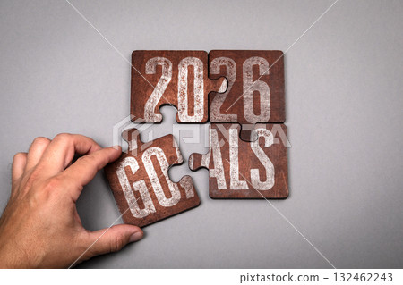2026 Goals Concept. Hand placing wooden puzzle piece 132462243