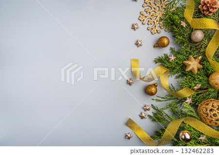 Golden Christmas Decorations with Greenery on Light Background 132462283