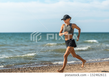Female runner sprinting, Female athlete executing powerful sprint with agility amidst surf spray and energetic coaching Female runner sprinting, Female athlete executing powerful sprint with agility amidst surf spray and energetic coaching 132462611
