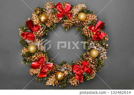 Close-up of Christmas wreath on dark grey background. Close-up of Christmas wreath on dark grey background. 132462614