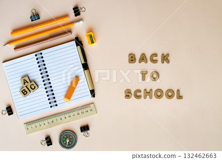 Open notebook with pencils, pens, ruler, compass and eraser on beige background back to school 132462663
