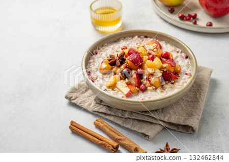 Overnight oatmeal with apple, cranberry, honey and cinnamon in a plate on a light background 132462844